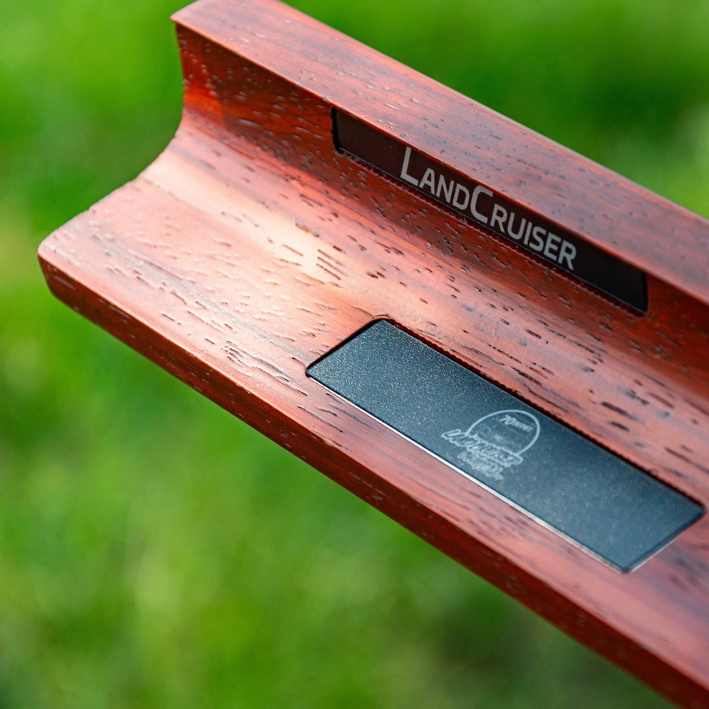 Wooden product with 'LandCruiser' branding on a blurred green background