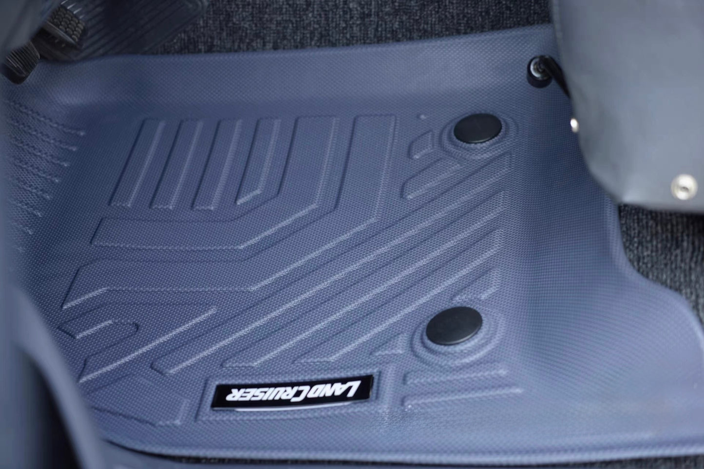 Car floor mat with a brand logo on a vehicle interior background Land Cruiser lc80