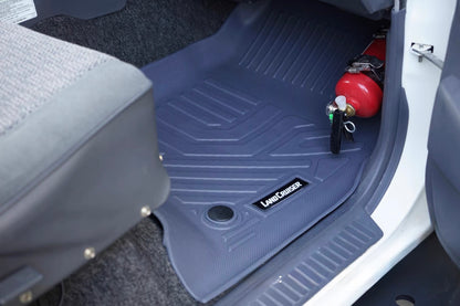 gray Car floor mat with a brand logo on the side Land Cruiser, placed inside a vehicle with red fire extinguisher 