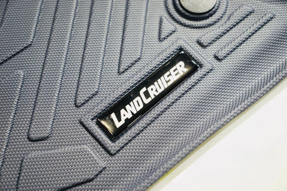 Gray car rubber mat with 'LandCruiser' logo on a white background
