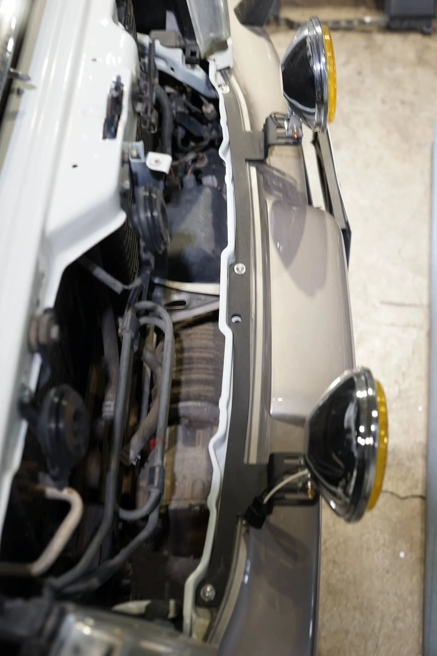 Top view of dual light bracket installed on Toyota Land Cruiser 100 Series bumper