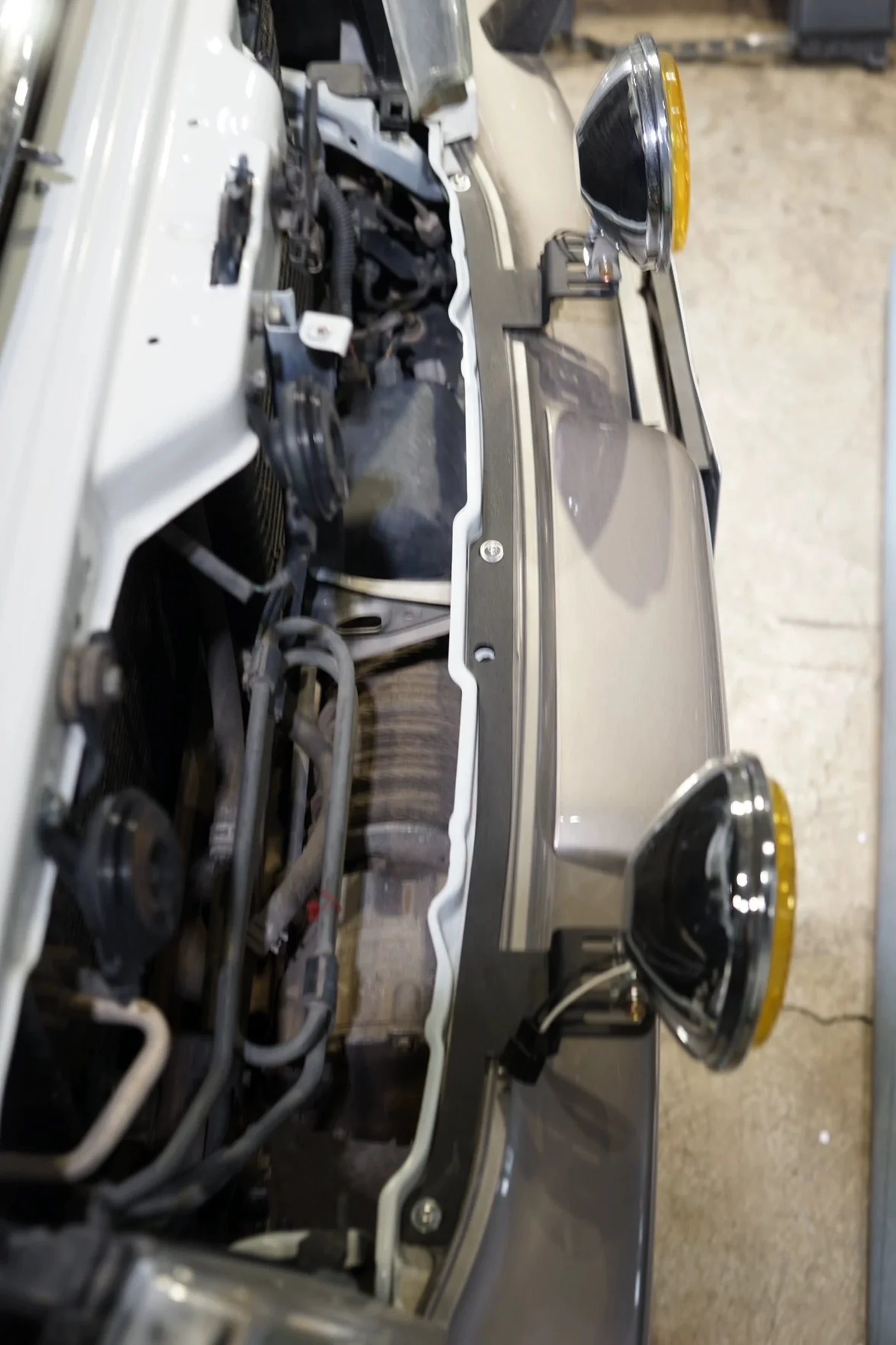 Top view of dual light bracket installed on Toyota Land Cruiser 100 Series bumper