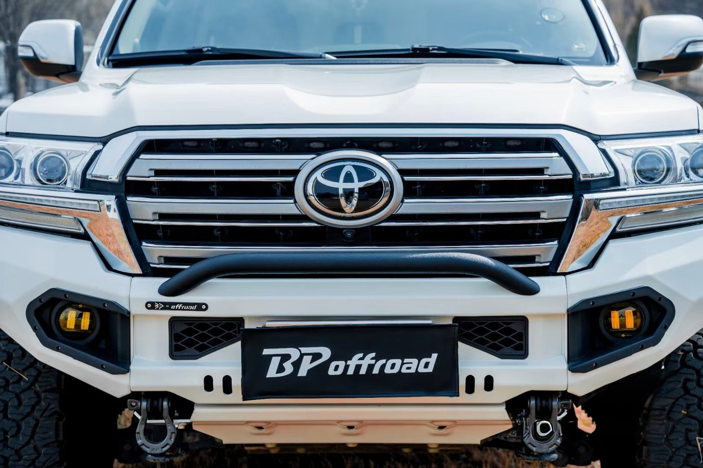 White Toyota lc200 front end vehicle with BP Offroad bumper in a forest setting