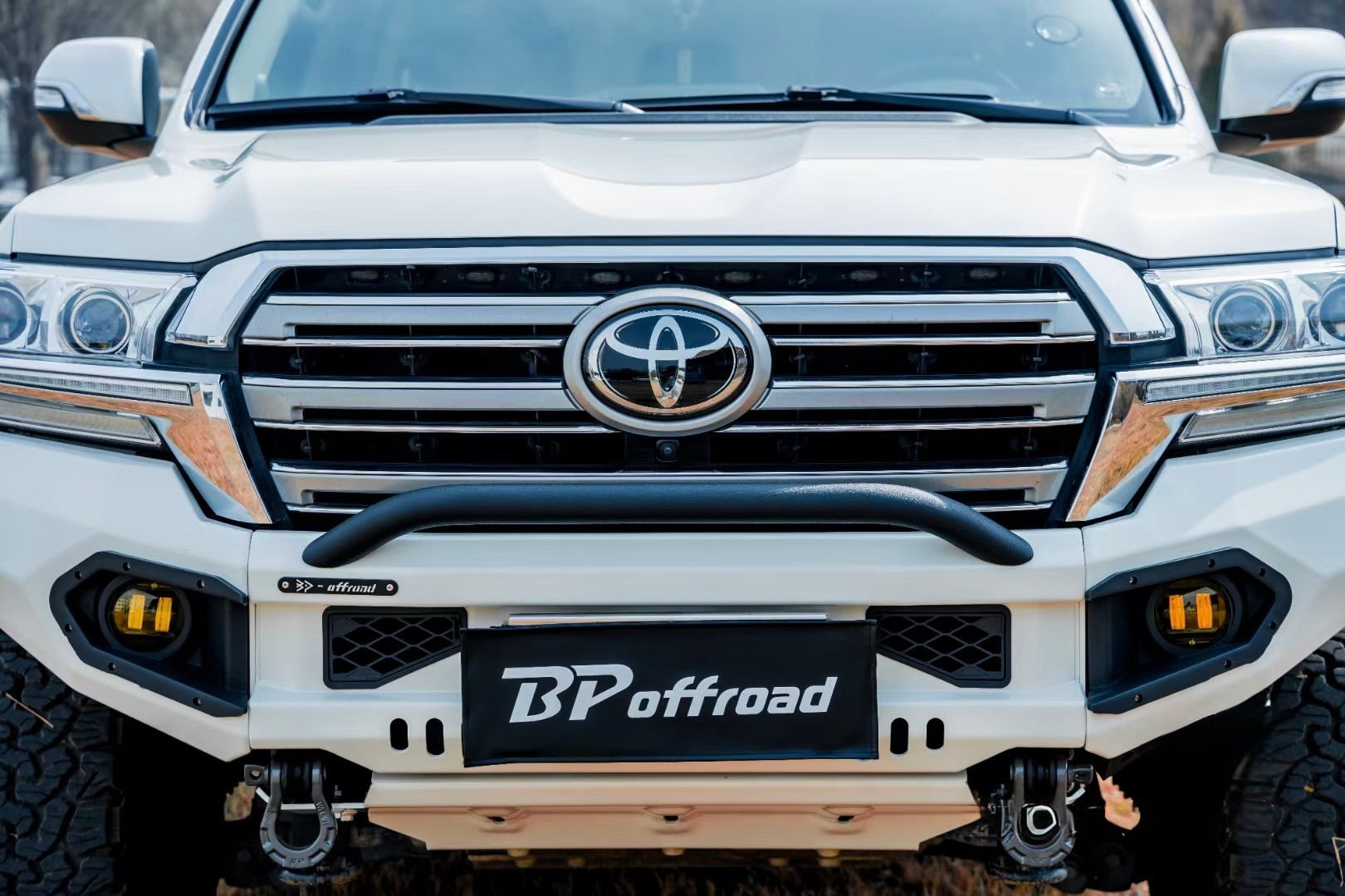 White Toyota lc200 front end vehicle with BP Offroad bumper in a forest setting