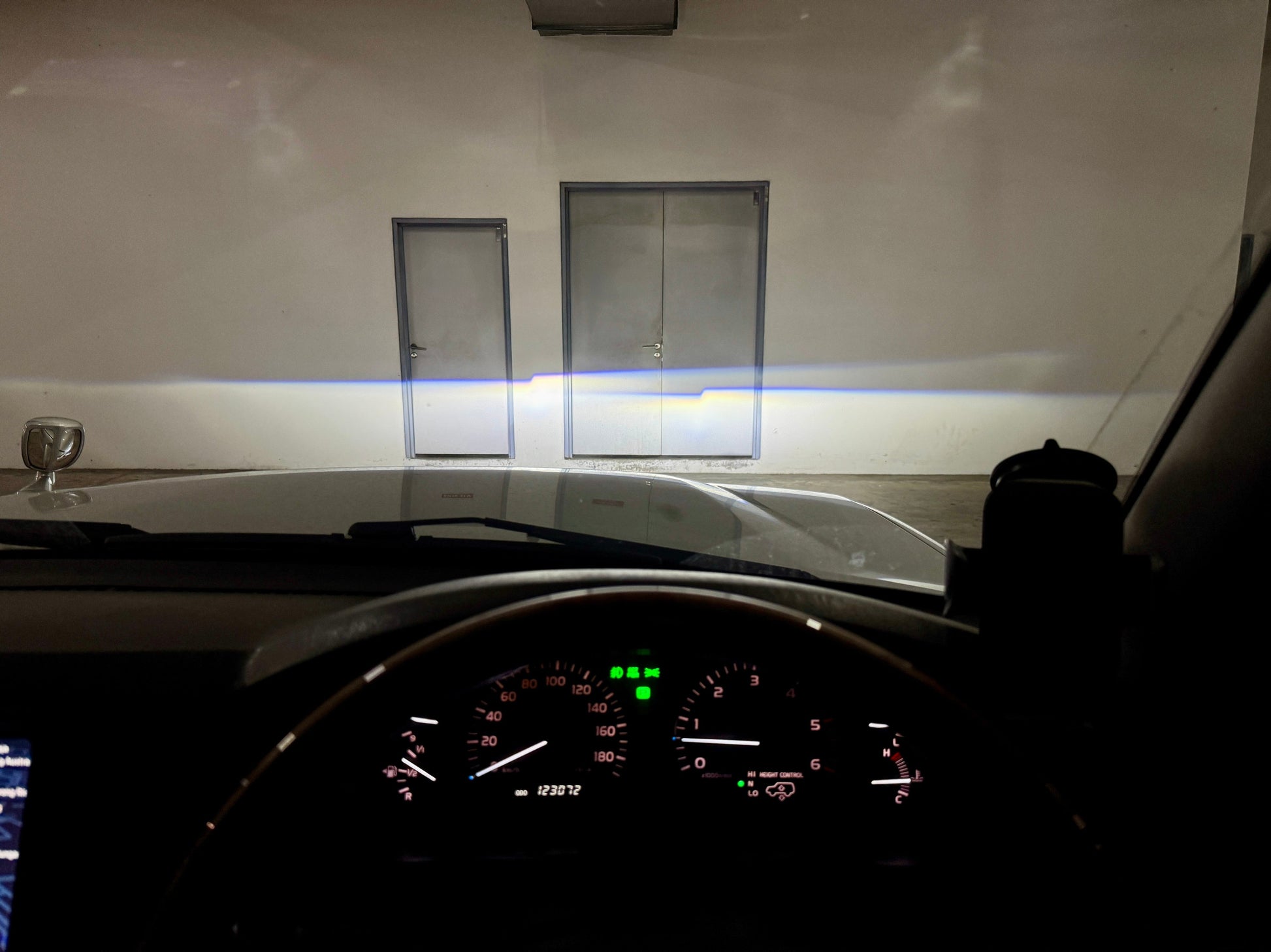 Ninja Cruiser Toyota Land Cruiser 100 Series facelift LED projector headlights showing bright, wide beam illumination on a wall.