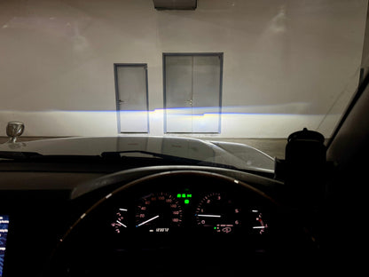 Ninja Cruiser Toyota Land Cruiser 100 Series facelift LED projector headlights showing bright, wide beam illumination on a wall.