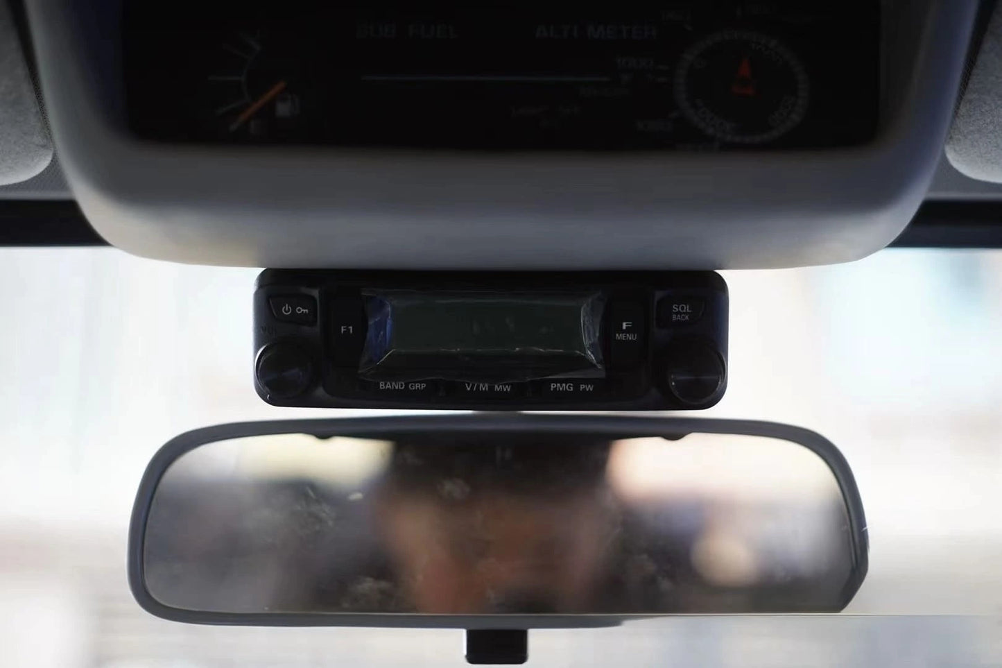 CB radio bracket installed on dash of Land Cruiser 80 Series with rear view mirror and altitude meter sub fuel