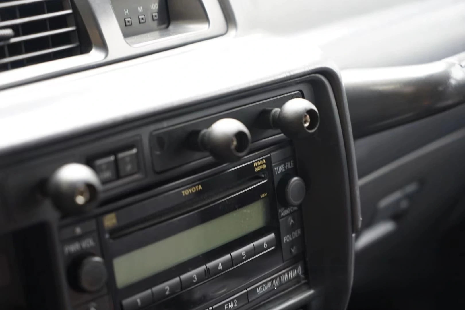 Set of dual universal gadgets phone mount installed on Land Cruiser 80 series dash close up zoom