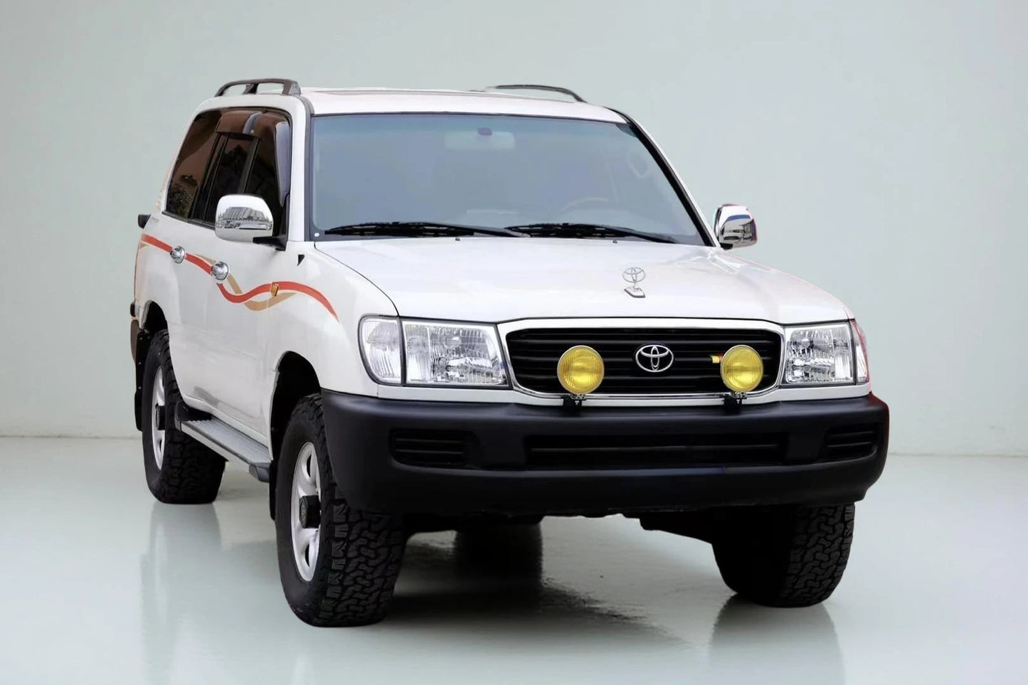 Toyota Land Cruiser 100 yellow fog light kit mounted on front grille