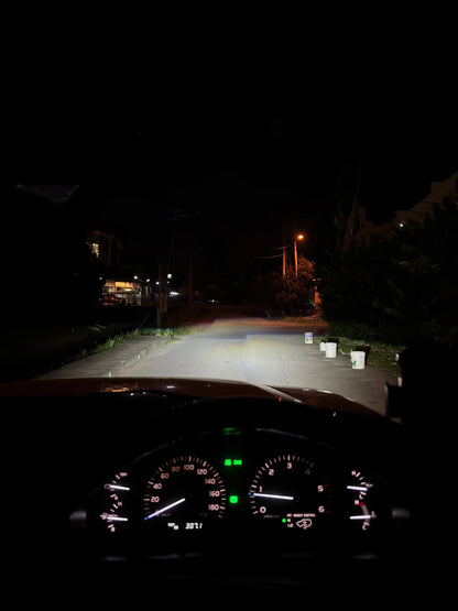 Car dashboard view at night on a dark street with powerful led headlight wide beam on the road