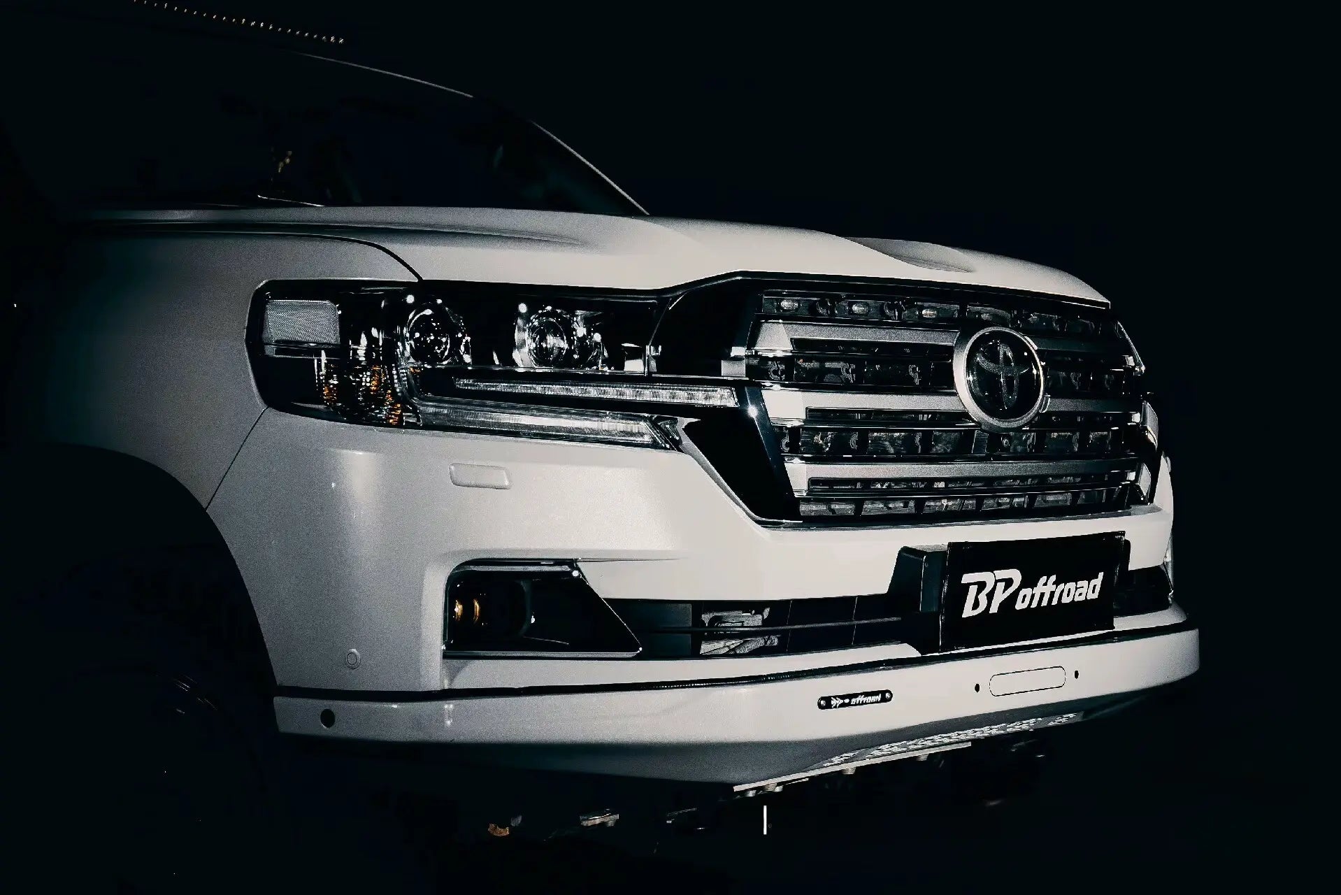 White facelift toyota LC200 vehicle with 'BP Offroad' front white steel bumper on a black background