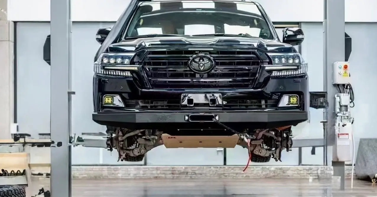 Black facelift Toyota LC200 SUV on a lift in a workshop setting