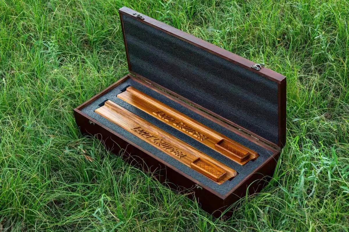 LC70 Series Luxury Wood Door Armrest Set in Premium Box - Both natural wood armrests packaged in a protective, hinged wooden box with foam inserts, emphasizing the luxury presentation on grass