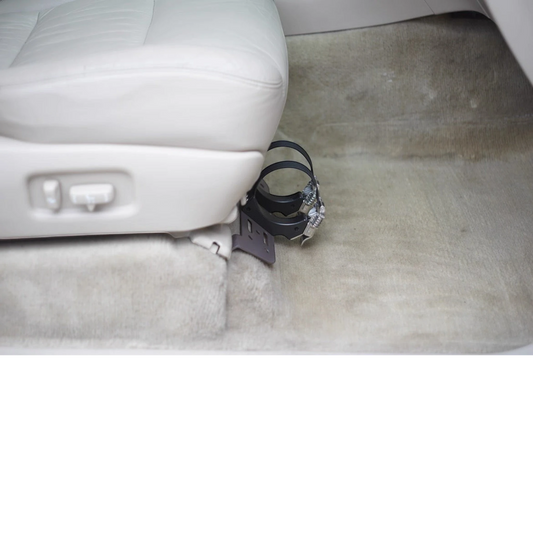 Ninja Cruiser black steel fire extinguisher bracket mounted under the passenger seat of a Toyota Land Cruiser 100 Series.