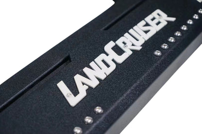 Ninja Cruiser custom black aluminum rock slider side step with white "Land Cruiser" logo for Toyota Land Cruiser 80 series.