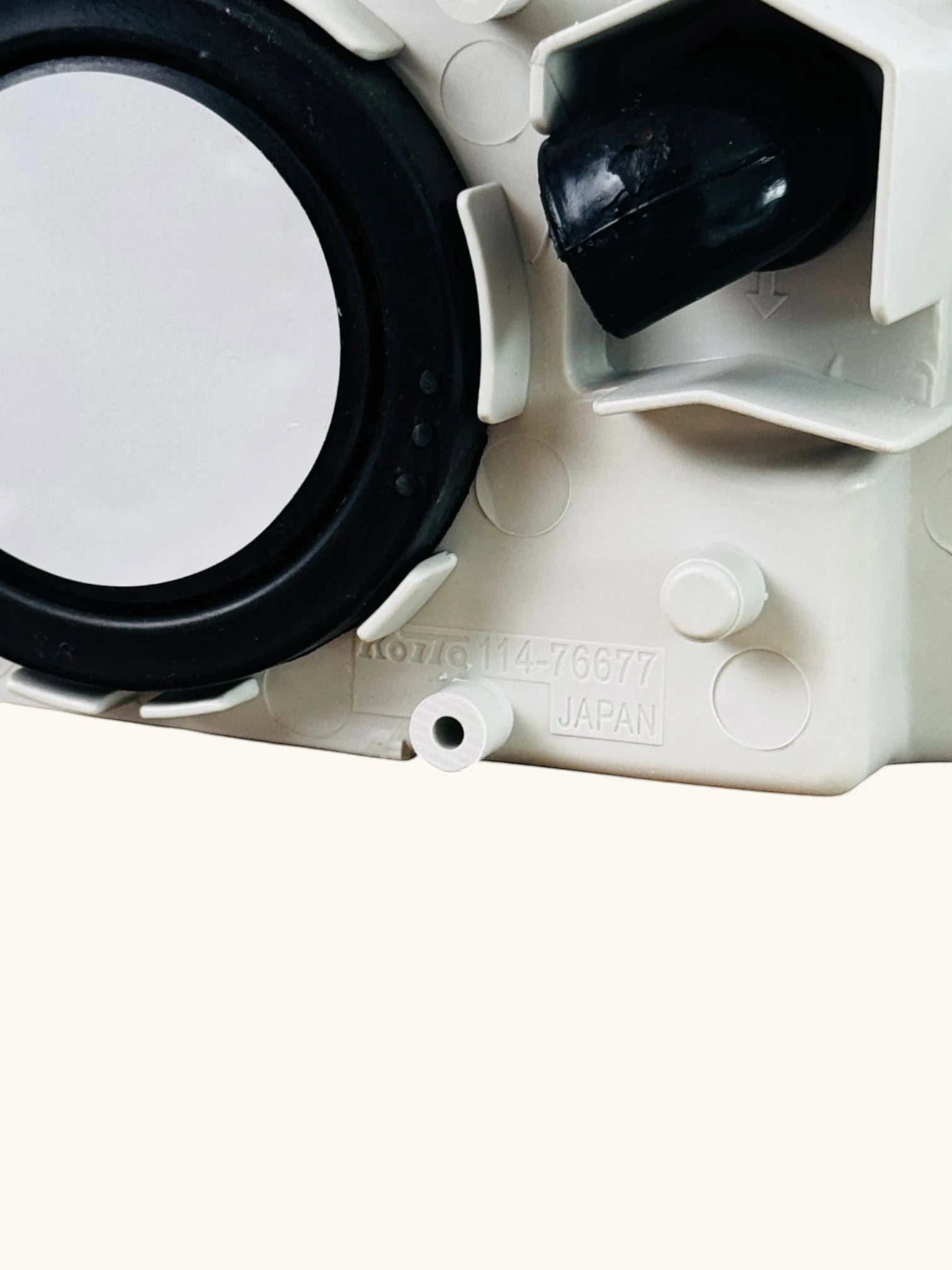Ninja Cruiser Genuine Toyota LC100 front fog lamp housing, written Koito Japan, made in Japan. White plastic with black rubber seal.