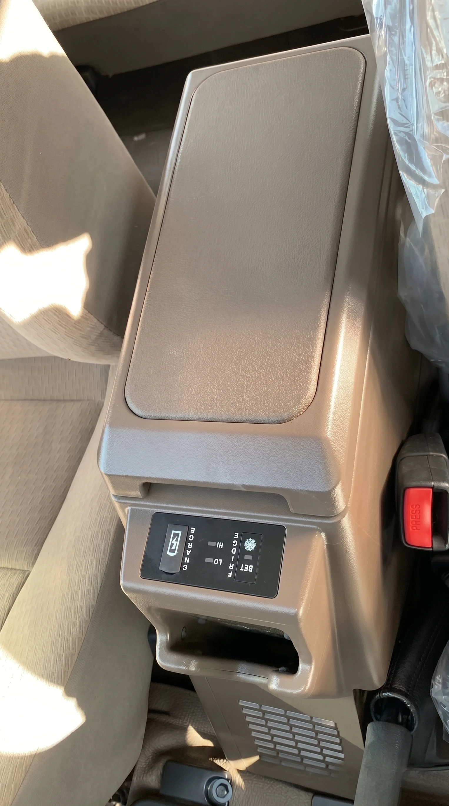 Toyota Land Cruiser 76 centre console fridge installed in brown interior view showing factory-fit look
