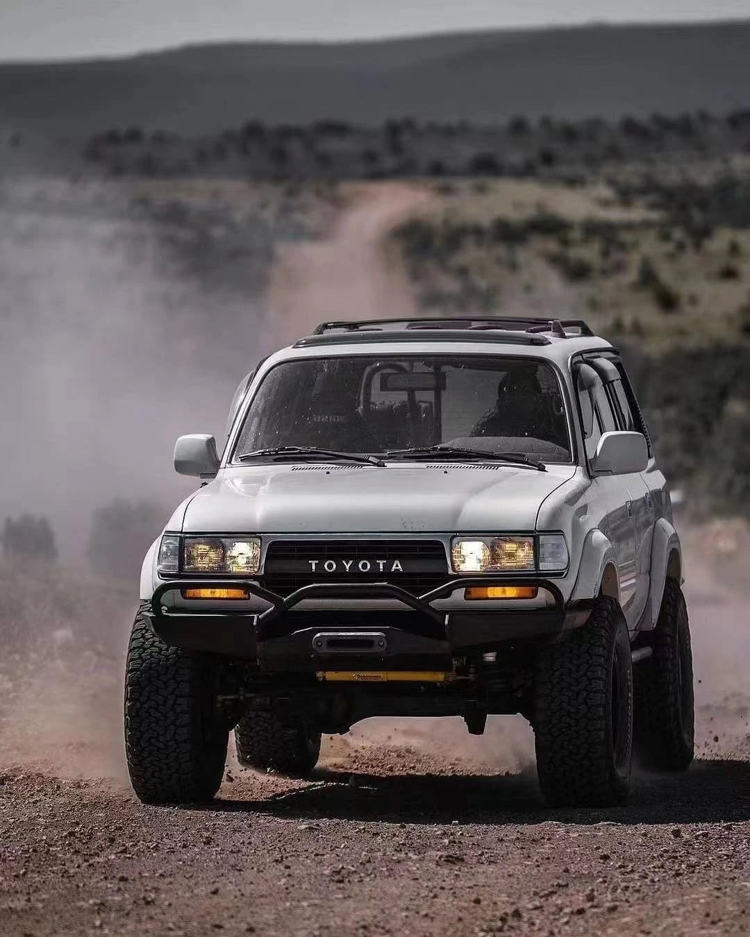 Toyota Land Cruiser 80 Series or Lexus LX450 fitted with Slee-Shortbus style heavy duty front bumper with fairlead mount for off-road protection running on gravel road