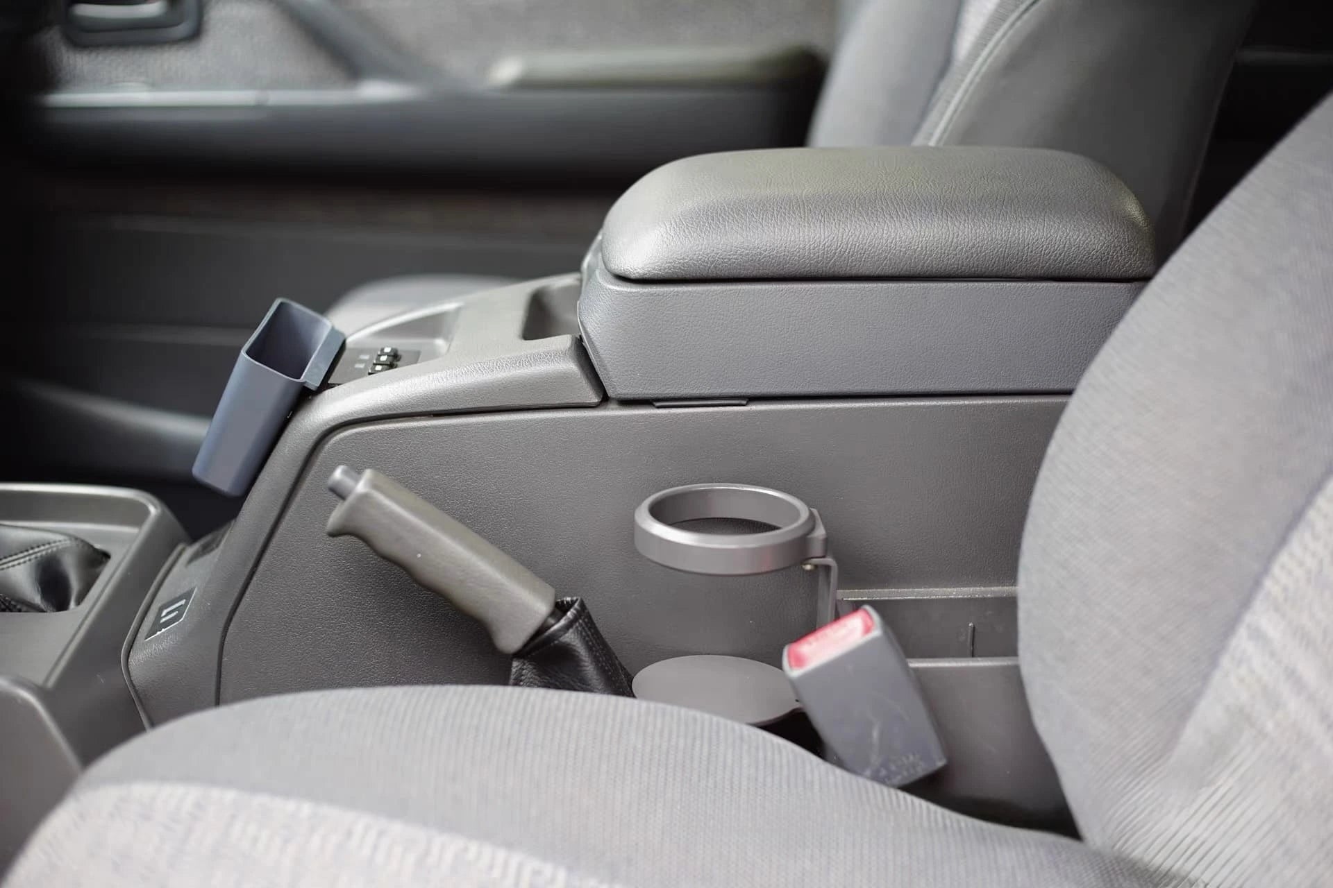 Toyota Land Cruiser 80 Series cup holder mounted to center console, middle arm rest side view shown without drink zoom in