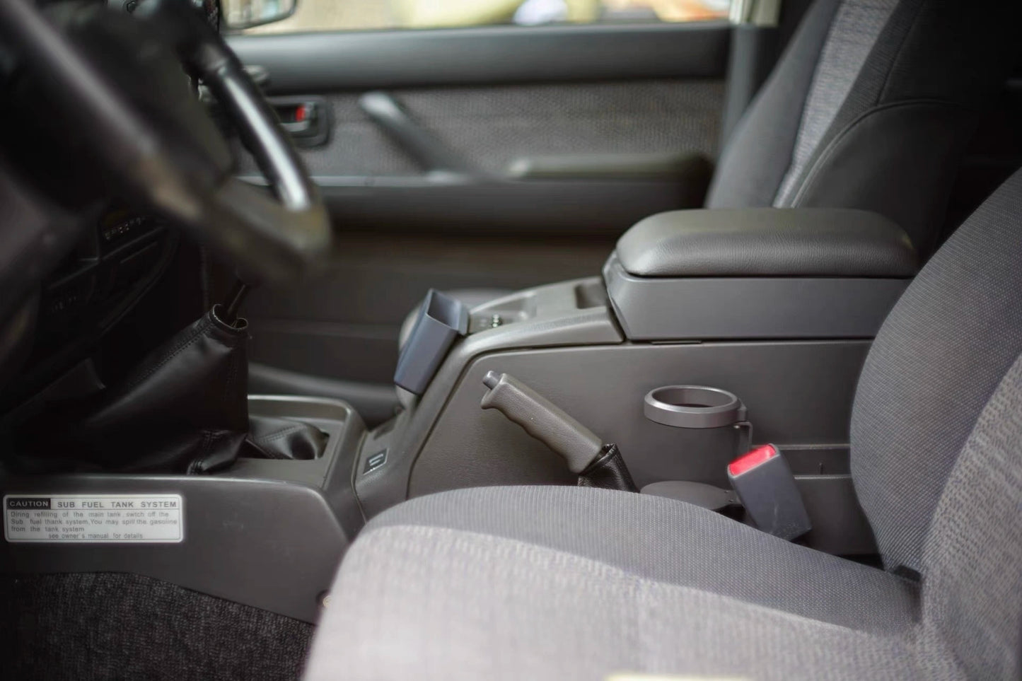 Toyota Land Cruiser 80 Series cup holder mounted to center console, shown without drink closed up